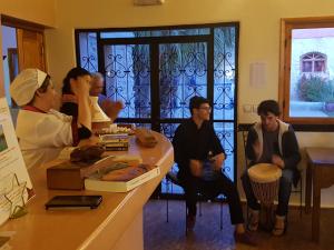 a group of people sitting around a counter in a room at Douar Noujoum in Essaouira +139 photos