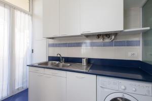 a white kitchen with a sink and a dishwasher at Casa del Mare in Sanremo +21 photos