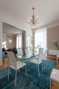 Casa del Mare في سانريمو: غرفة طعام مع طاولة زجاجية وكراسي بيضاء