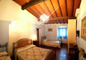 um quarto com 2 camas e um lustre em B&B Casale Ginette em Incisa in Valdarno