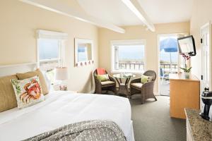 1 dormitorio con 1 cama, mesa y sillas en Chatham Tides en South Chatham