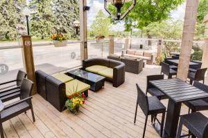 a patio with tables and chairs and a couch at West Wing at Park Town in Saskatoon