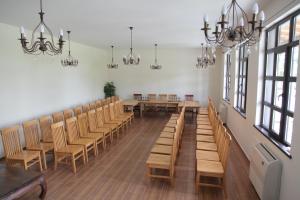 a room with wooden tables and chairs and chandeliers at Villa Bulgara Eco in Madara