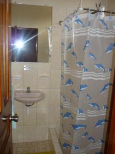 uma casa de banho com uma cortina de chuveiro com golfinhos em Sol de Playa em Playas