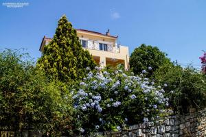 een huis bovenop een stenen muur met bloemen bij Gythio Seaside Villa Dimitrios - Panoramic View in Gythio