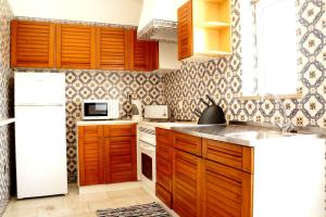 een keuken met houten kasten en een witte koelkast bij Monte Sao Pedro - Villa in Luz