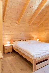 LoučoviceにあるApartmany Lipno - Dvorecnaの木製の部屋にベッド1台が備わるベッドルーム1室があります。