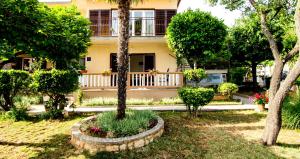 una casa con un árbol en un patio en Apartman Darja en Umag