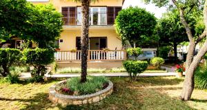 a house with a tree in a yard at Apartman Darja in Umag