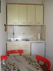 a kitchen with a table and a sink and cabinets at Apartman Darja in Umag