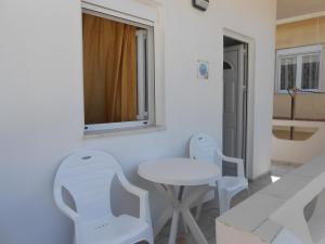 Biały stół i krzesła w pokoju z oknem w obiekcie Frosso's Apartments w mieście Kokkini Hani +37 zdjęć