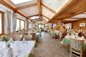 a restaurant with tables and chairs in a room at Hotel Hubertusstube in Laion