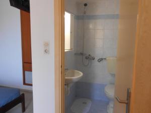 łazienka z toaletą i umywalką w obiekcie Frosso's Apartments w mieście Kokkini Hani