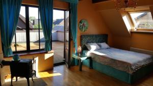 ein Schlafzimmer mit einem Bett und einem Balkon in der Unterkunft Peahen Residence in Sigulda
