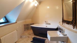 a bathroom with a sink and a bath tub at Peahen Residence in Sigulda