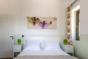 een slaapkamer met een wit bed en bloemen aan de muur bij White Villas in Karavomylos +29 foto's