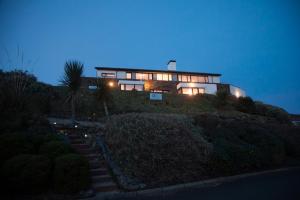 uma casa sentada no topo de uma colina à noite em Sea Vista Boutique Accommodation em Fahan