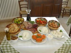 a table with plates of food and baskets of vegetables at Agriturismo Masseria Casedde Vecchie in Martina Franca