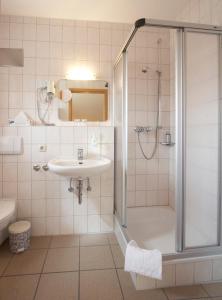 ein Bad mit einem Waschbecken und einer Dusche in der Unterkunft Hotel Company in Cölbe