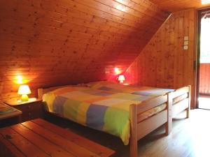 een slaapkamer met een bed in een houten hut bij Chalet Iskaretreat in Ig