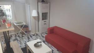 コンスタンツァにあるTourist's Delight Apartmentのリビングルーム(赤いソファ、テーブル付)