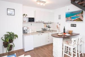 een keuken met witte kasten en een tafel bij Apartments Miraflores in Split