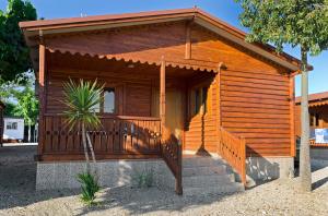 una piccola cabina in legno con portico e scale di Camping Carlos III a La Carlota