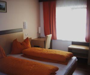 埃本塞的住宿－羅特奈旅館，卧室配有2个橙色枕头