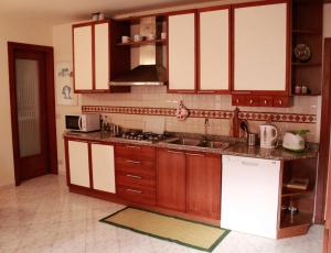 a kitchen with brown and white cabinets and a sink at Bacanal Apartment in Venice