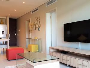a living room with a television and a glass table at Zimbali Suites 304 in Ballito