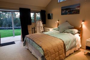 a bedroom with a bed and a large window at For Puffed Pedallers in Mapua
