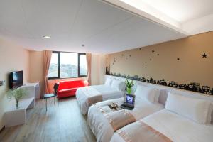 a hotel room with two beds and a couch at Hotel Taiwan Changhua in Changhua City