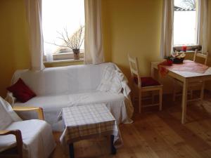 a living room with a white couch and a table at Fewo DD- Wilschdorf in Dresden +4 photos