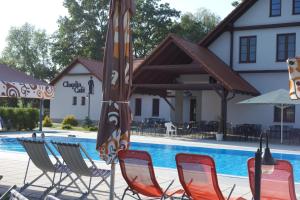 um grupo de cadeiras e um guarda-sol junto a uma piscina em Lednicko-valtický apartmán em Hlohovec