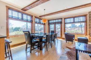 a dining room with a table and chairs and windows at Yukimi # 1 in Kutchan