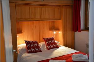une chambre avec un lit avec des oreillers rouges dessus dans l'établissement La Grangette - Morzine, à Morzine