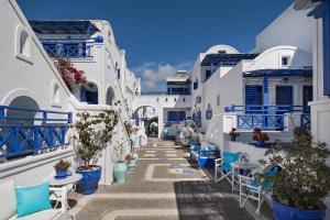 a street with blue and white buildings and chairs at Samson΄s Village in Perissa