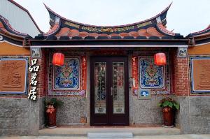 a building with a door with chinese writing on it at Teapot House in Jinning