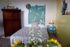 a bedroom with a bed with a blue headboard and flowers at Magic Garden House in Cali