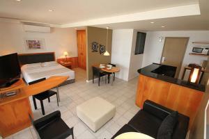 Habitación de hotel con cama y sala de estar. en Beach Apartments - GMT, en Río de Janeiro