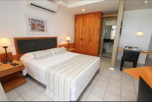 1 dormitorio con cama, escritorio y cocina en Beach Apartments - GMT, en Río de Janeiro
