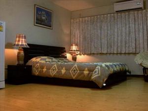 a bedroom with a bed with two lamps on it at Condo Muang Thong in Nonthaburi