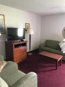 a living room with a couch and a flat screen tv at Lake Tree Inn & Suites in Marion