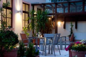 een patio met tafels, stoelen en planten bij Hotel Lucia in Wenen
