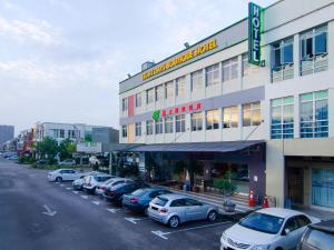 um grupo de carros estacionados num parque de estacionamento em frente a um edifício em Eight Days Boutique Hotel - Mount Austin em Johor Bahru