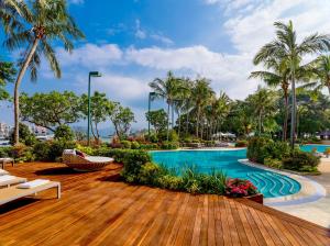 a pool at a resort with palm trees at Hong Kong Gold Coast Hotel in Hong Kong