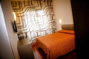 a bedroom with a orange bed and a window at Hotel Giada in Turin