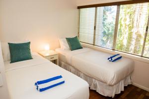 two twin beds in a room with a window at Alamanda - Suite 46 in Palm Cove
