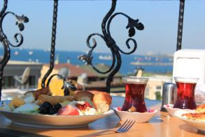 a table with two plates of food and two drinks at Asmali Hotel in Istanbul