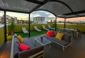 a rooftop patio with couches and a table and chairs at Breeze Lodge in Brisbane